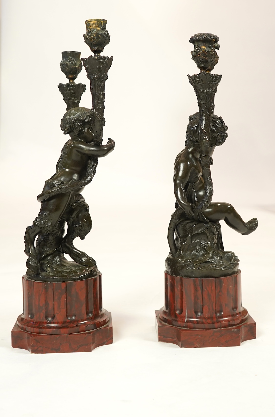 After Clodion. A pair of mid 19th century French bronze two branch figural candelabra
